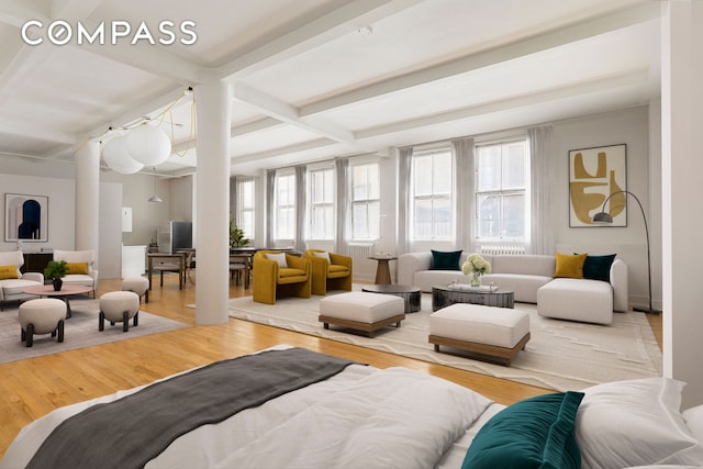 bedroom featuring baseboards, beam ceiling, and wood finished floors