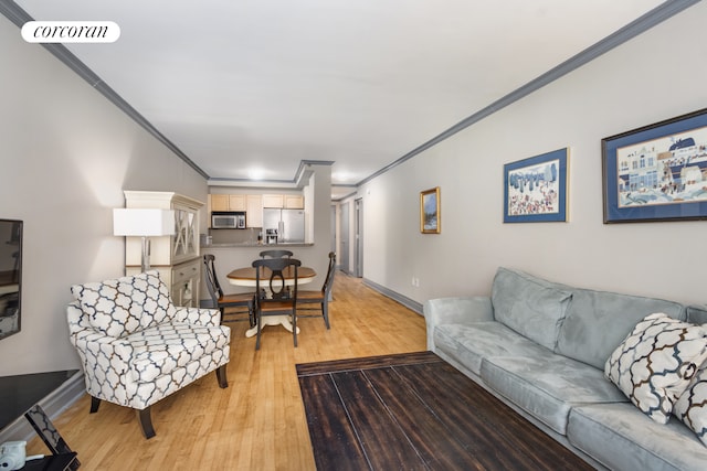 living room featuring visible vents, baseboards, ornamental molding, and light wood finished floors