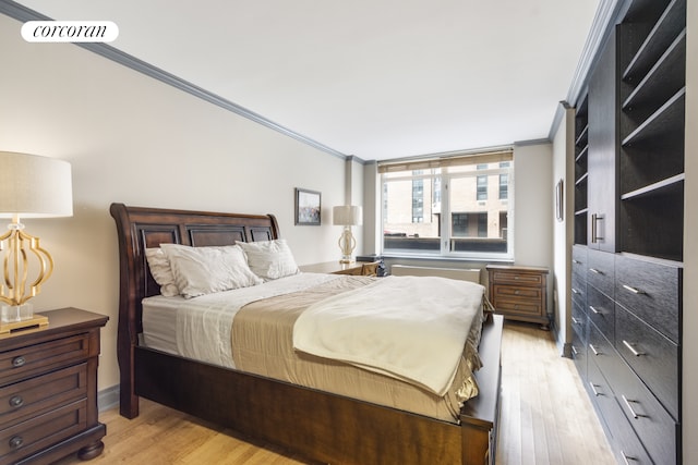 bedroom featuring visible vents, ornamental molding, and light wood finished floors