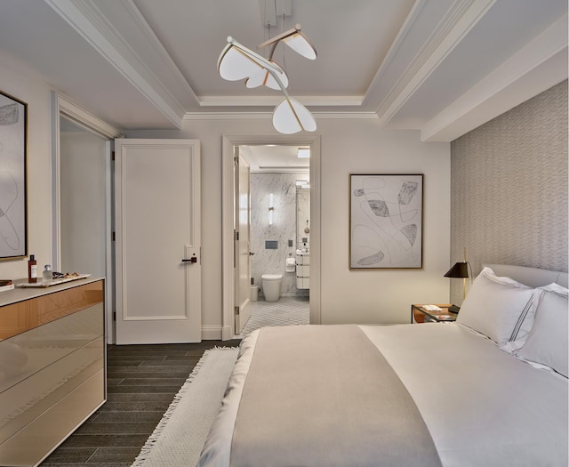 bedroom featuring dark wood-style flooring, ornamental molding, ensuite bath, and a raised ceiling