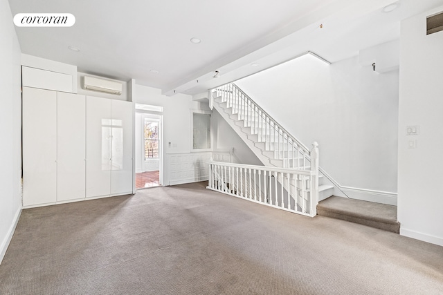 unfurnished living room with carpet flooring, baseboards, visible vents, and a wall mounted air conditioner