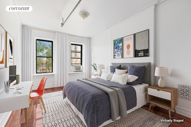 bedroom featuring visible vents, cooling unit, and wood finished floors