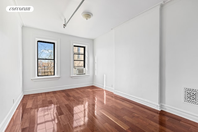 unfurnished room featuring visible vents, baseboards, and wood finished floors