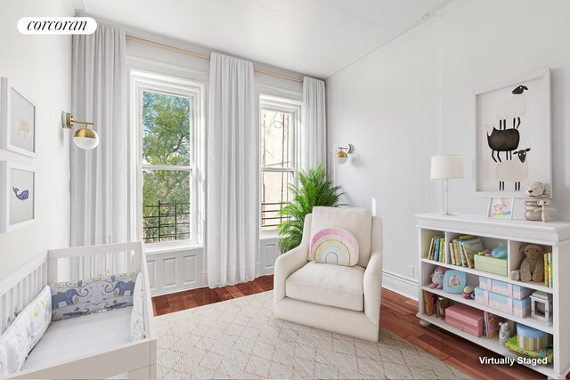 living area featuring a wealth of natural light, visible vents, baseboards, and wood finished floors