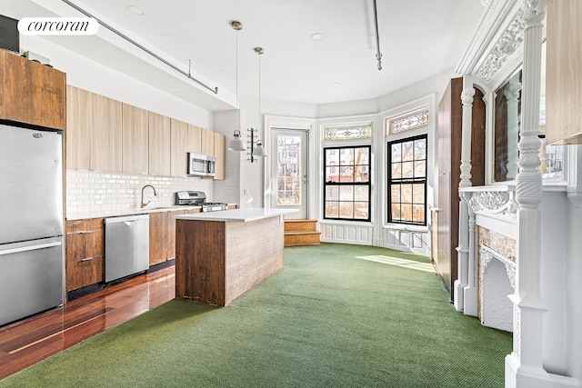 kitchen with a kitchen island, light countertops, appliances with stainless steel finishes, modern cabinets, and dark carpet