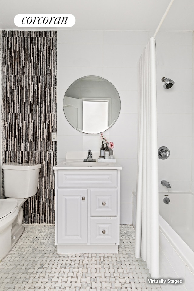 bathroom with toilet, tile walls, vanity, and shower / tub combo