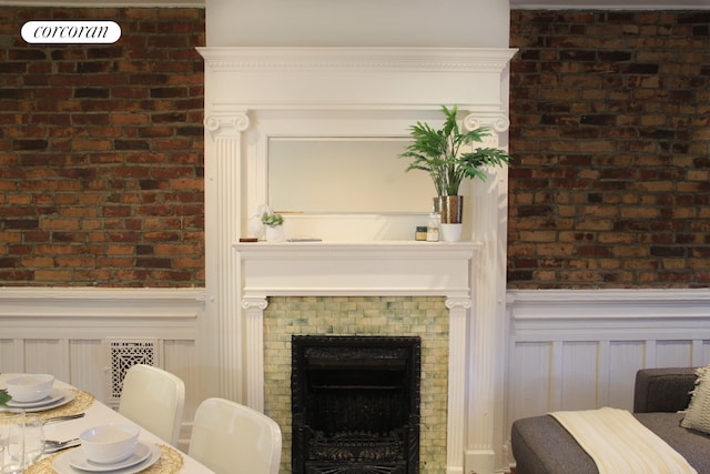 interior space featuring radiator heating unit, a fireplace, and a wainscoted wall