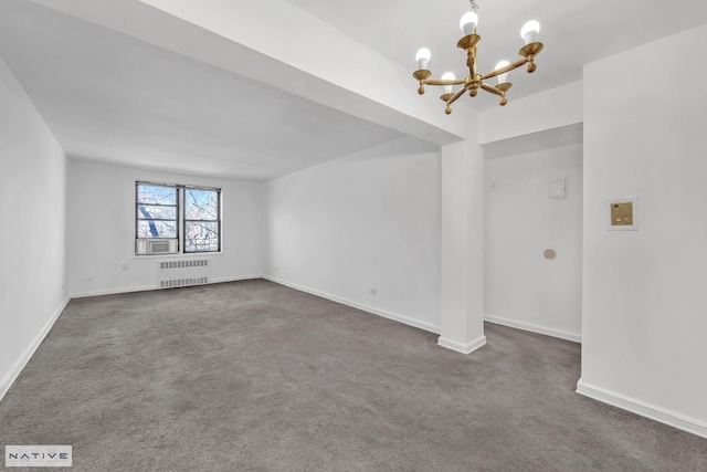 spare room featuring radiator heating unit, baseboards, dark colored carpet, and a chandelier