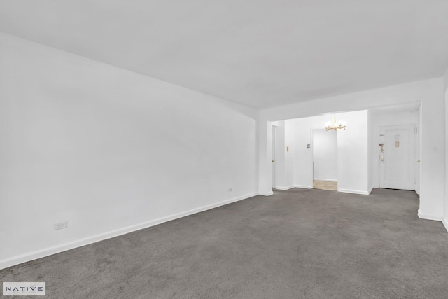 unfurnished room featuring a notable chandelier and baseboards