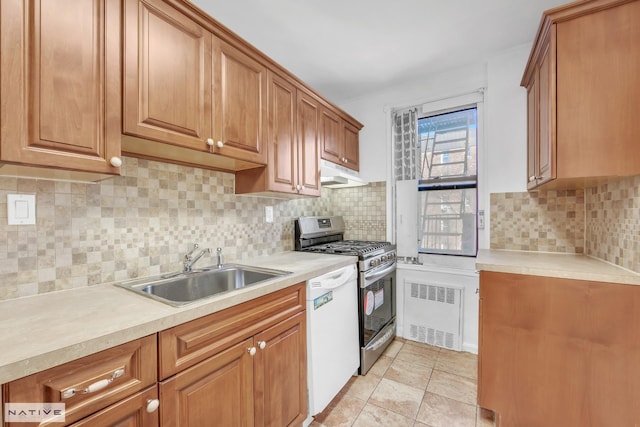 kitchen featuring under cabinet range hood, a sink, gas stove, white dishwasher, and light countertops