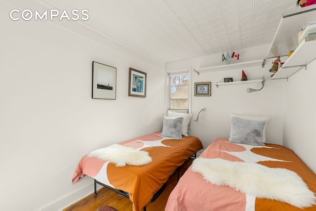 bedroom featuring wood finished floors and baseboards