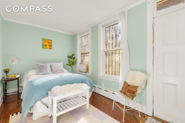 bedroom featuring wood finished floors, baseboards, and ornamental molding