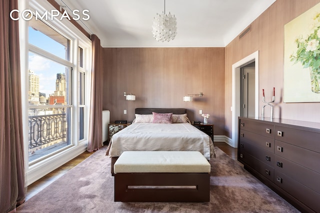 bedroom with a chandelier, visible vents, a view of city, and dark wood-type flooring