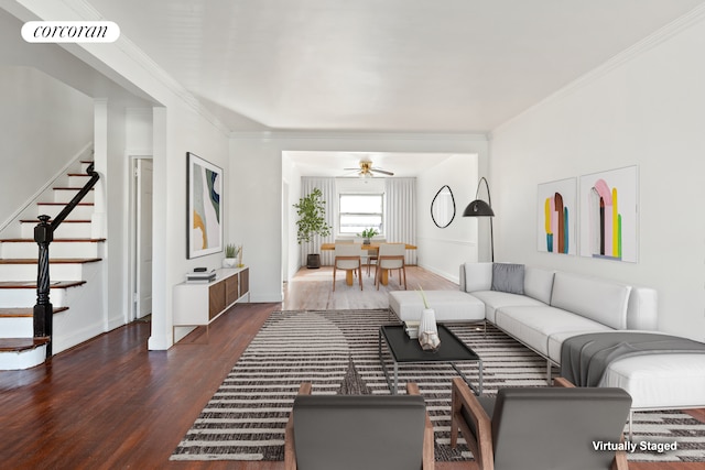 living area with wood finished floors, visible vents, a ceiling fan, ornamental molding, and stairs