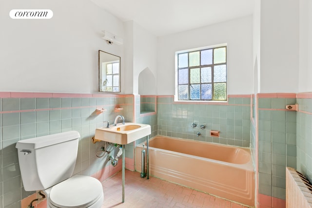 bathroom with a wainscoted wall, visible vents, toilet, tile walls, and a bath