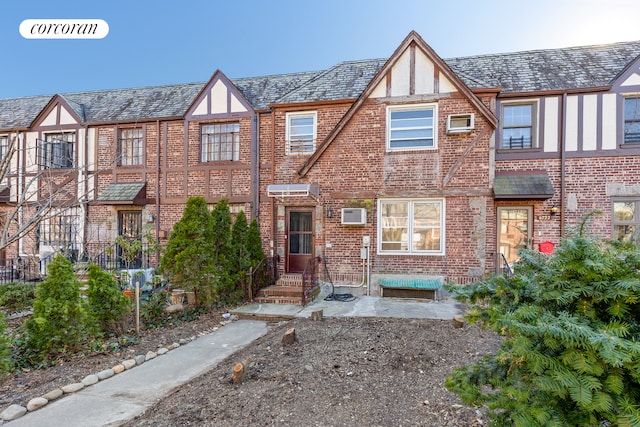 view of front of property with brick siding, a high end roof, and entry steps