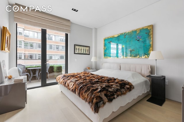 bedroom featuring access to outside, multiple windows, and light wood finished floors