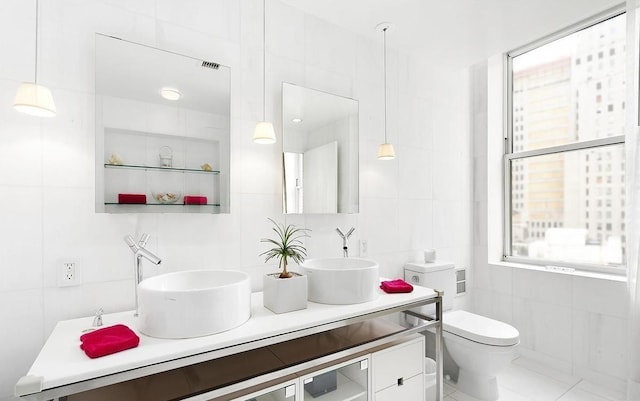 bathroom featuring tile walls, vanity, and toilet