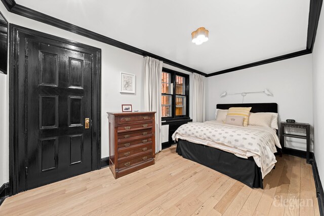 bedroom with baseboards, wood finished floors, and ornamental molding