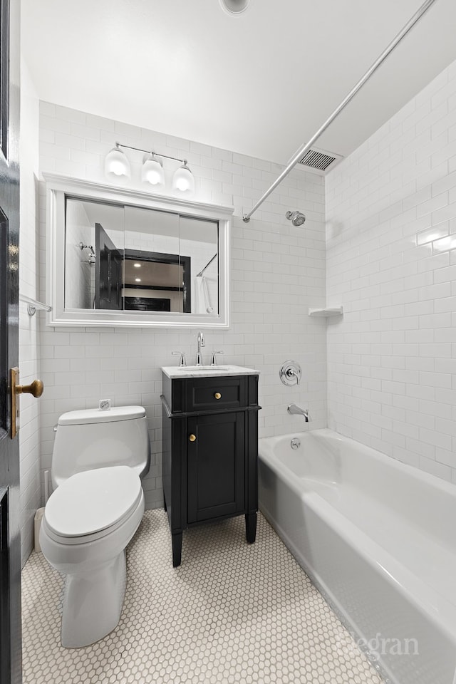 full bath featuring vanity, visible vents, tile walls, toilet, and shower / bathtub combination