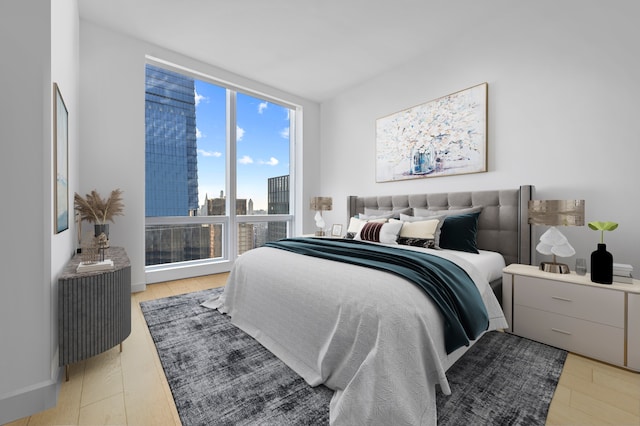 bedroom with light wood-style floors and floor to ceiling windows