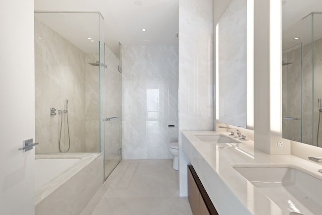 bathroom featuring double vanity, a shower with door, toilet, tile walls, and a tub with marble appearance