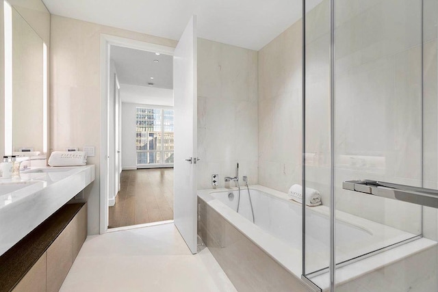 full bathroom featuring double vanity, an enclosed shower, and a bath