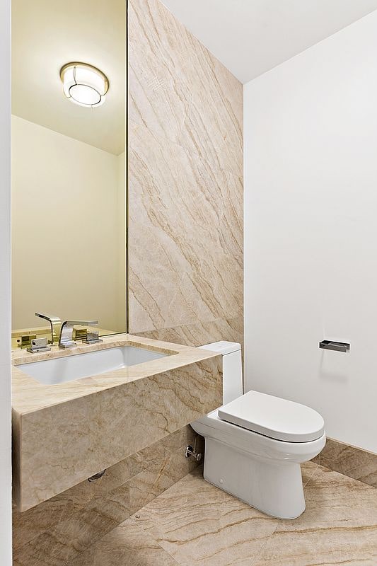 bathroom with toilet, tile patterned floors, and a sink