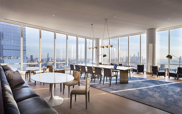 dining area featuring floor to ceiling windows, a view of city, and wood finished floors