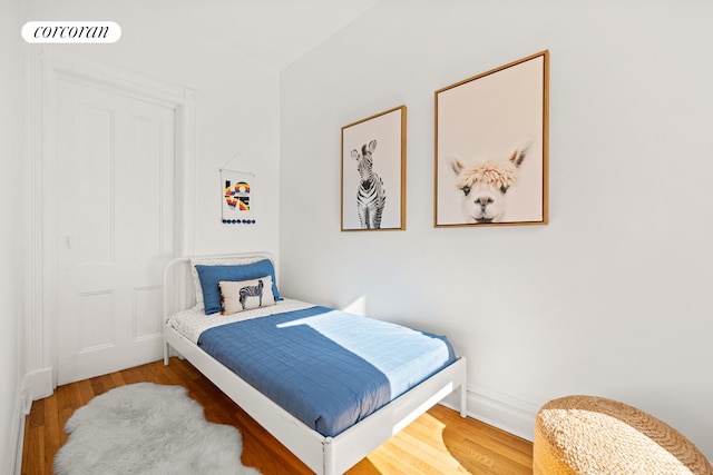 bedroom with visible vents, baseboards, and wood finished floors