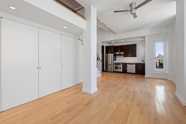 unfurnished living room featuring light wood-type flooring, recessed lighting, stairway, baseboards, and ceiling fan