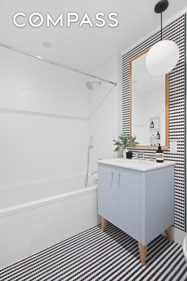 full bathroom featuring tiled shower / bath combo, tile walls, vanity, and tile patterned floors