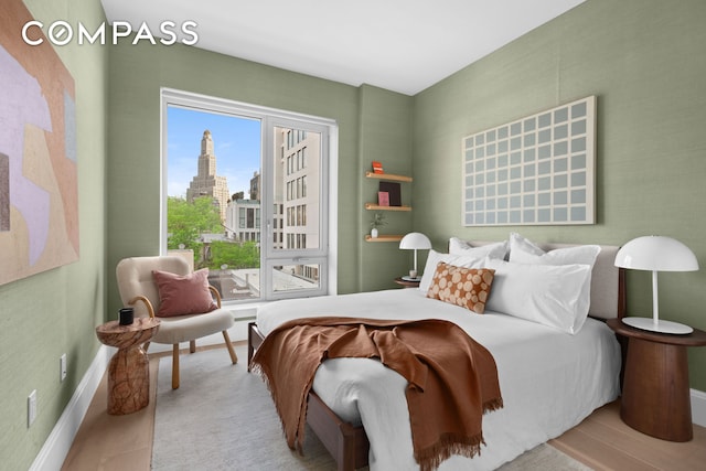 bedroom featuring baseboards, a city view, and access to exterior