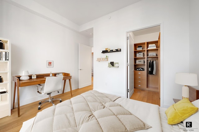 110 Charlton St Unit 20-G, New York City, NY 10014 - bedroom with wood finished floors, an office area, a spacious closet, a closet, and baseboards