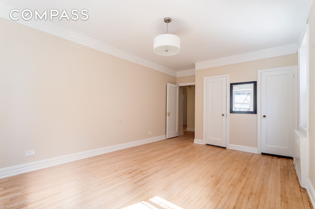 unfurnished bedroom with light wood-style flooring and baseboards