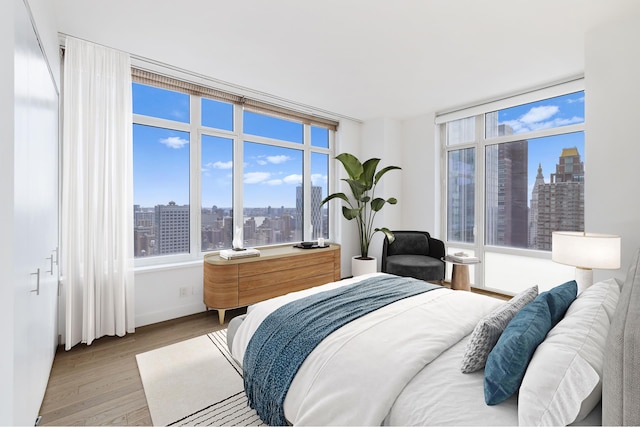 bedroom featuring a view of city and wood finished floors