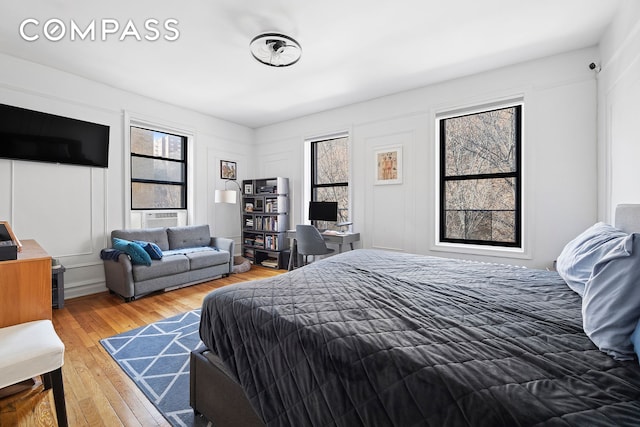 bedroom with a decorative wall and hardwood / wood-style flooring