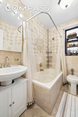 bathroom with tiled shower / bath, toilet, tile walls, and tile patterned flooring