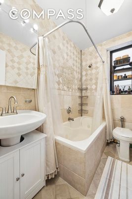 full bathroom featuring tile walls, tile patterned flooring, tiled shower / bath combo, toilet, and vanity