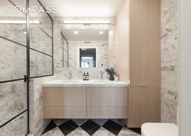 bathroom with tile walls, toilet, double vanity, and a sink