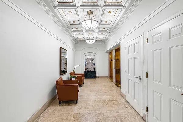 hall with baseboards, coffered ceiling, and crown molding