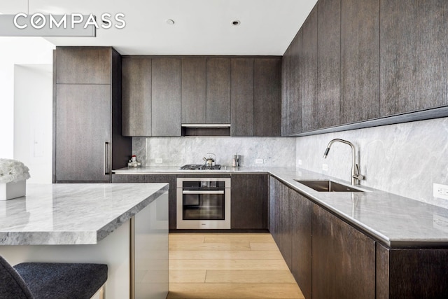 kitchen featuring dark brown cabinetry, appliances with stainless steel finishes, and a sink