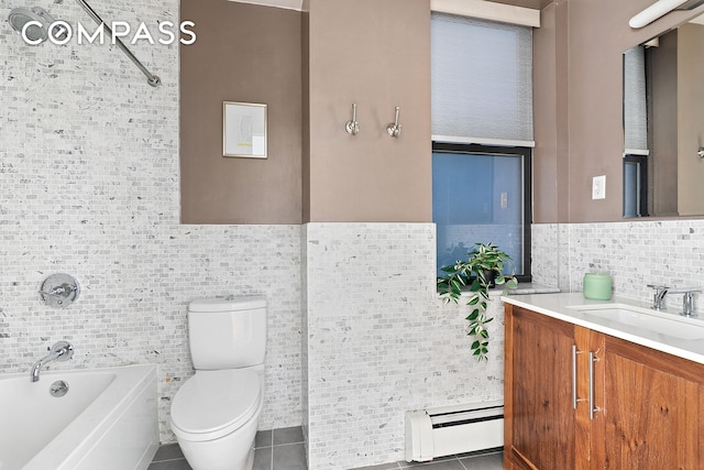 bathroom featuring tile patterned floors, toilet, a baseboard heating unit, tile walls, and vanity