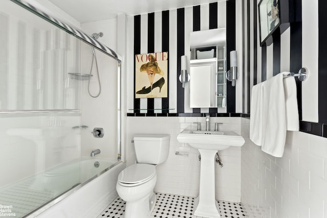 275 Greenwich St Unit 6G, New York City, NY 10007 - bathroom with toilet, shower / bath combination with glass door, tile patterned floors, and tile walls