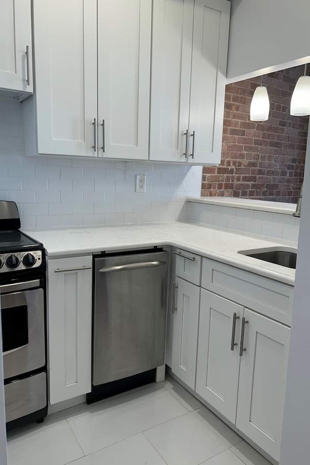 kitchen with a sink, light stone countertops, tasteful backsplash, and appliances with stainless steel finishes