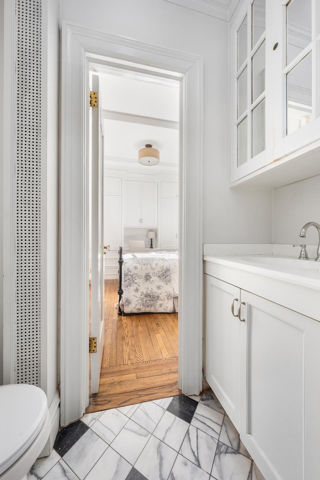 bathroom with vanity, a heating unit, marble finish floor, and toilet