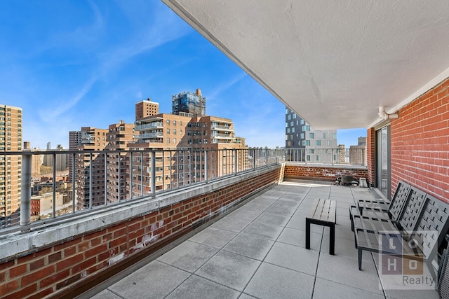 view of patio / terrace featuring a view of city and a balcony