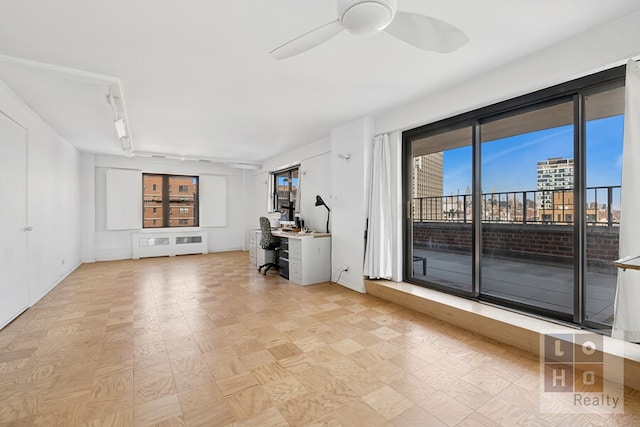 unfurnished living room featuring a ceiling fan