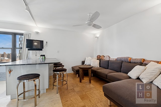 living area with ceiling fan and track lighting