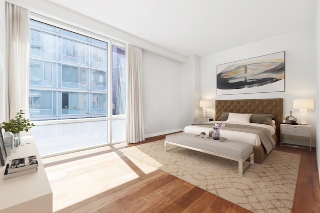 bedroom with baseboards and wood finished floors